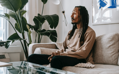 man on colour on a sofa wearing a beige jumper talking