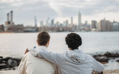 two males looking over a city with a hand over a shoulder