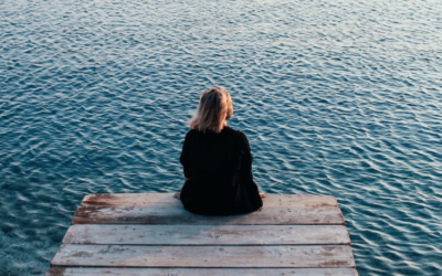 lady sitting by water staring ahead