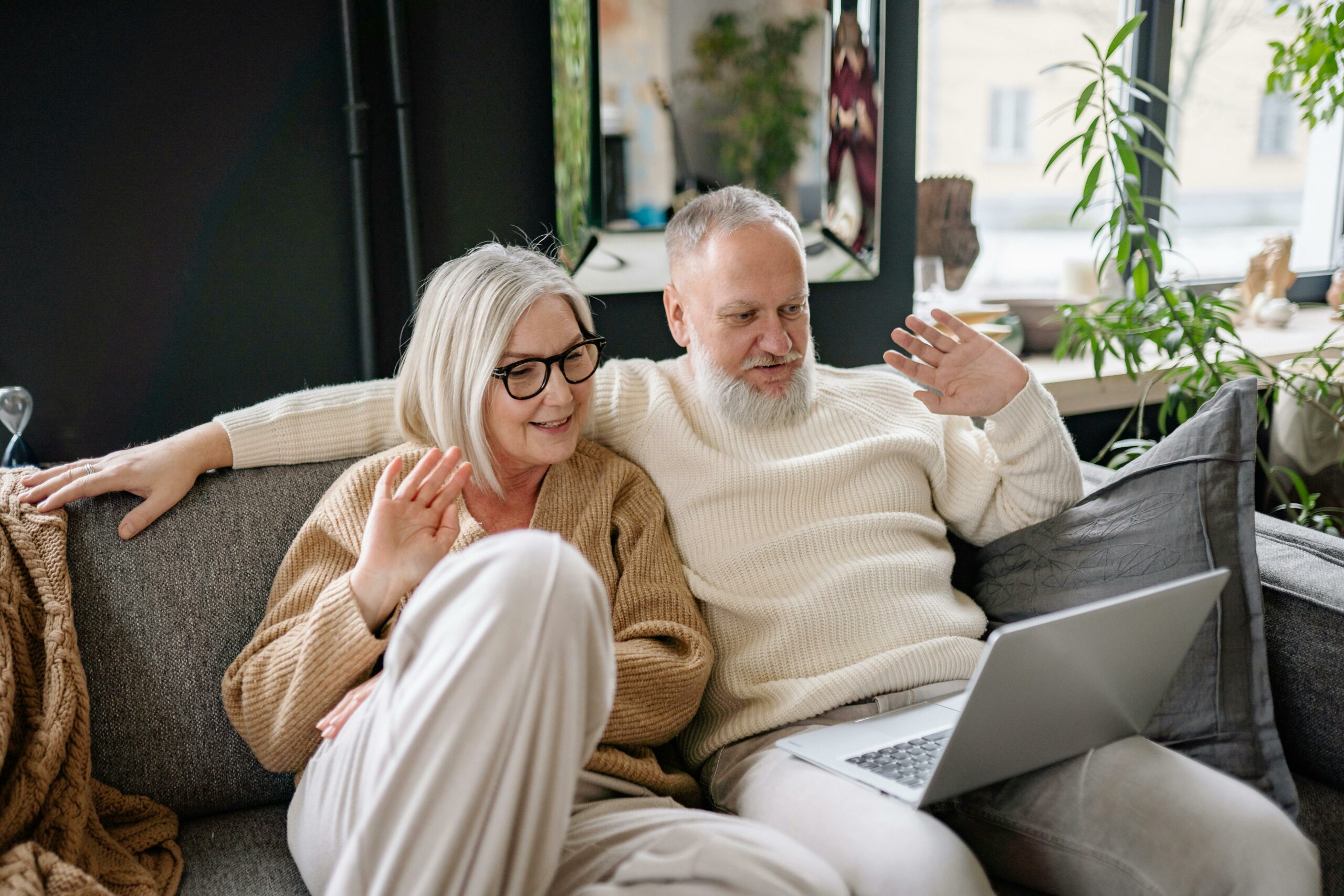 Cheerful father and daughter gathered round a laptop for a video call