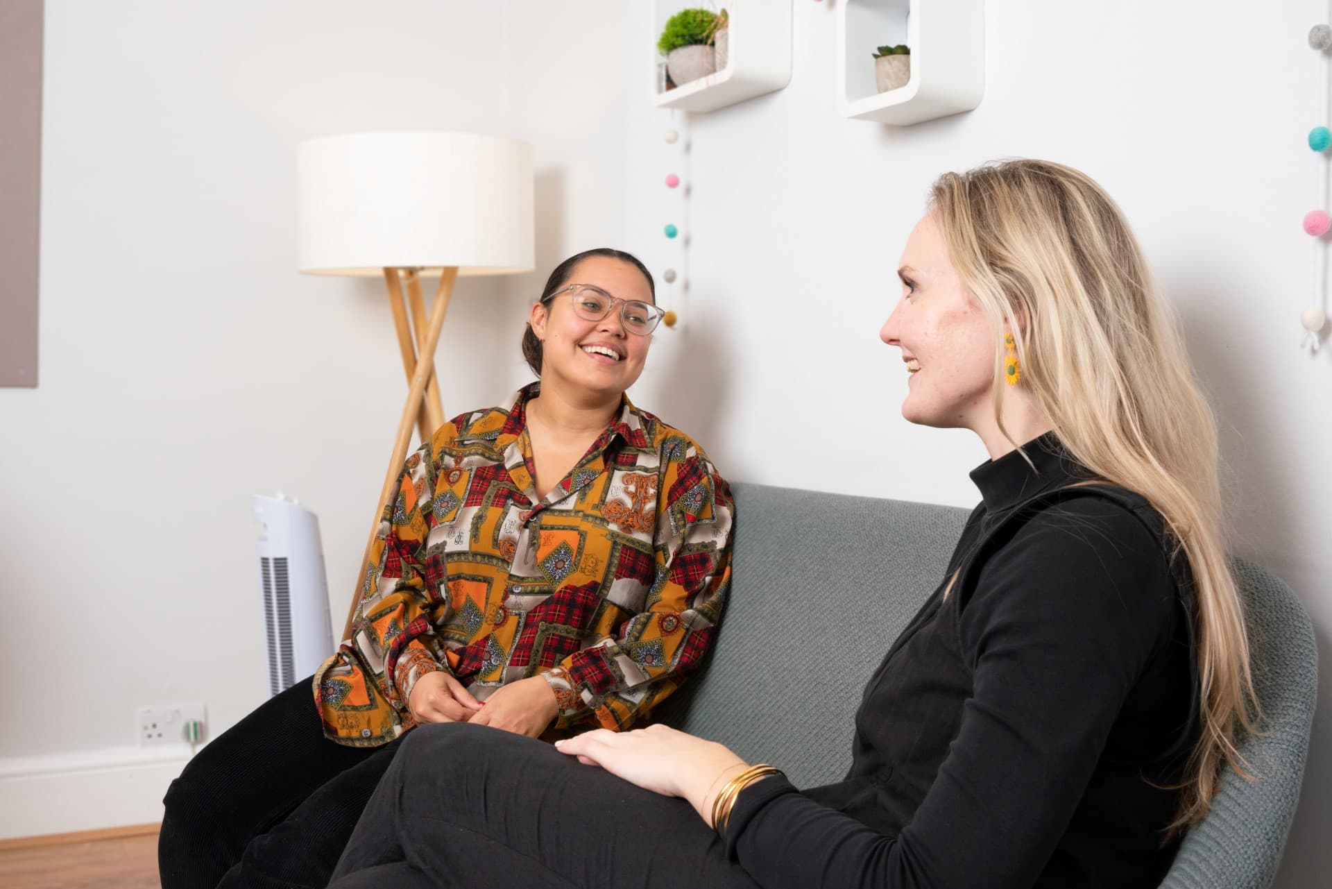 male chef wearing a striped apron holding up noodles with tongs
