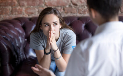 Young-Woman-Visiting-Therapist-Counselor-Girl-Feeling-Depressed | Orri A teenage girl is sitting across from a professional therapist, seeking support with an eating disorder.