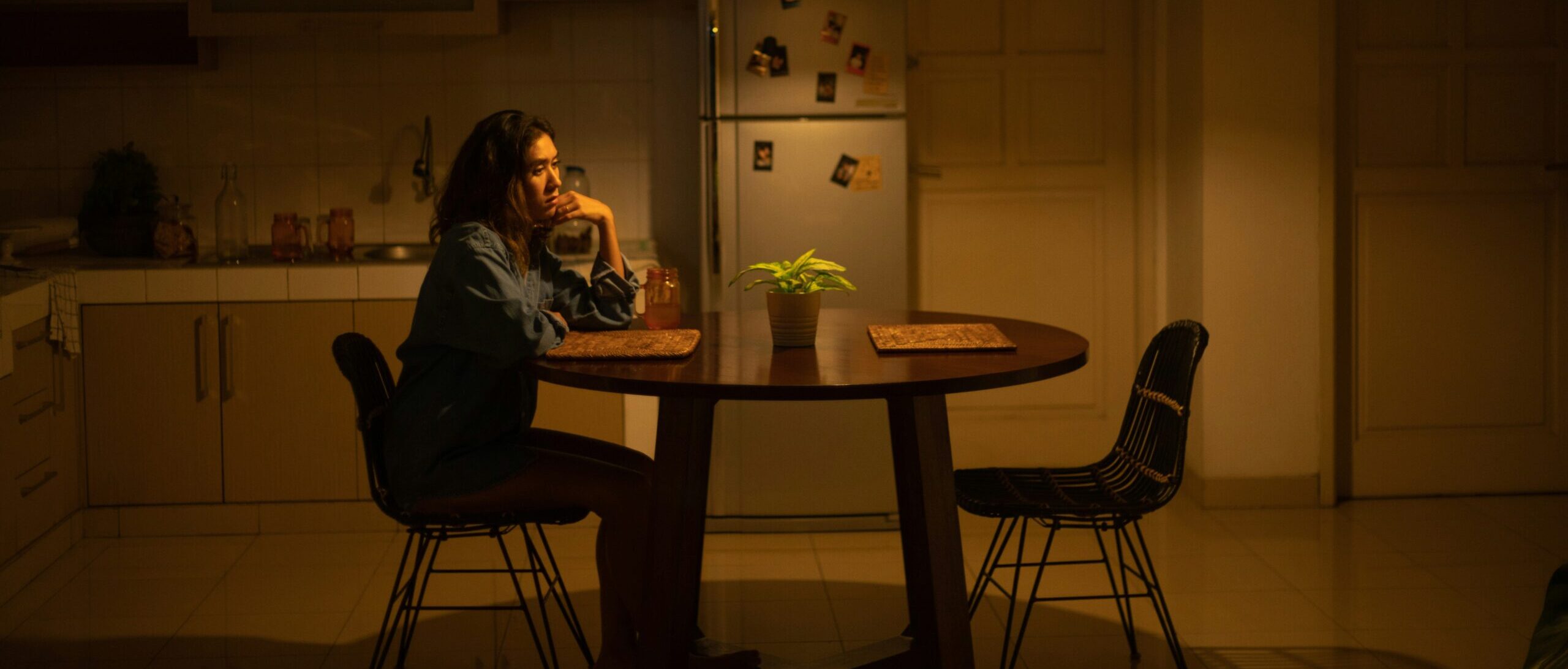 Disordered eating page: A woman sits alone at a table looking anxious.